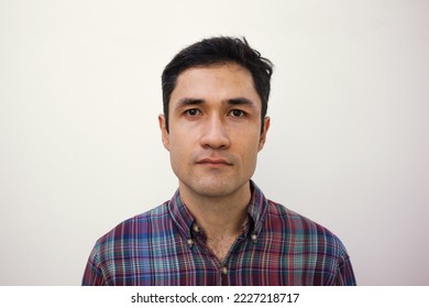 Male mugshot for passport. Serious portrait of adult man for id card. Visa picture. Soft focus. Film grain texture. Korean guy taking picture for papers in studio against white wall.  - Shutterstock ID 2227218717