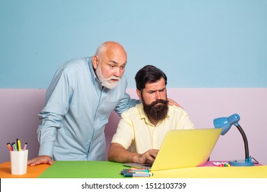 Male Multi Generation Family Using Internet. Senior Man Teaching Laptop To His Old Son. Two Man In Different Ages Working In Office