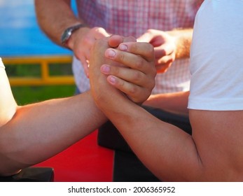 Male muscular arms in outdoor arm wrestling fight. Closeup photo