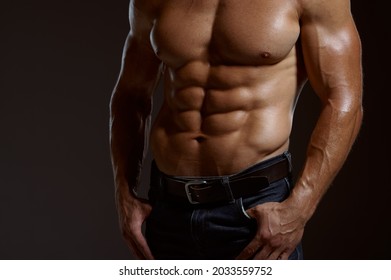 Male muscular athlete poses in studio