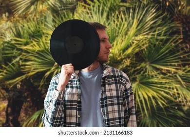 Male Music Lover Holding A Black Vinyl Record And Cover His Face 