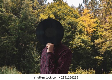 Male Music Lover Holding A Black Vinyl Record And Cover His Face 