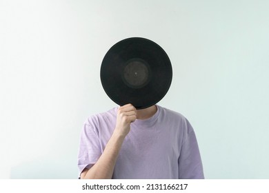 Male Music Lover Holding A Black Vinyl Record And Cover His Face 