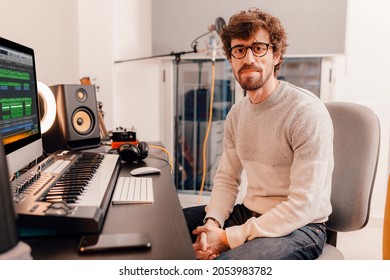 Male music producer working with his computer at home music studio. Millennial musician looking at camera. - Powered by Shutterstock