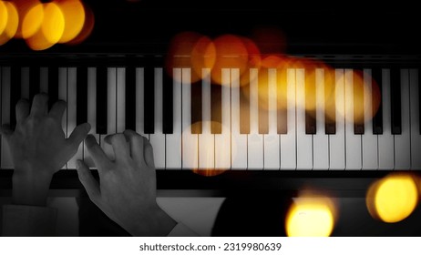 male musician hands playing on piano keys, black and white with golden light overlay. - Powered by Shutterstock