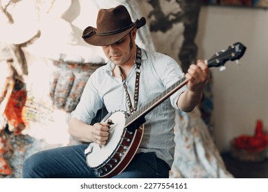 Male musician playing banjo sitting chair indoor.