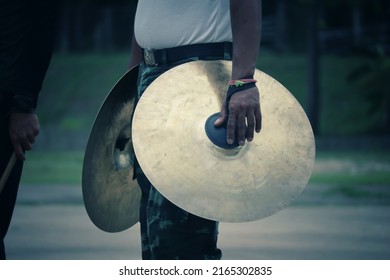 A Male Musician Playing Cymbals In An Outdoor Marching Band In The Morning.