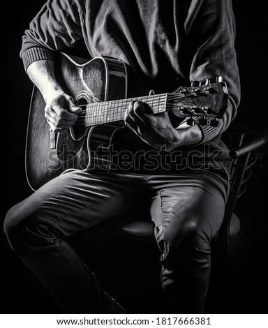 Male musician playing guitar, music instrument. Man's hands playing acoustic guitar, close up. Acoustic guitars playing. Music festival.