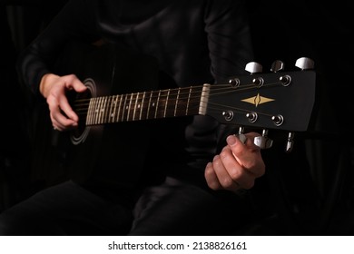 Male Musician Tuning The Strings On The Guitar