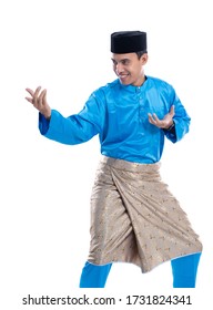 male muslim showing martial art move while wearing tradistional malay clothes