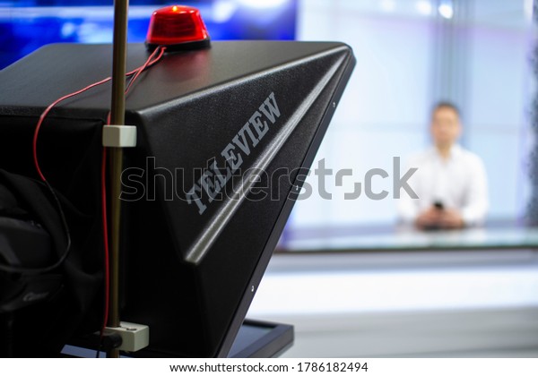 A male News anchor in a broadcast Studio reads text on\
a teleprompter. Camera in the TV Studio. News anchor in a TV Studio\
.