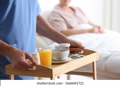 Male Nurse Bringing Food And Medicine For Patient In Hospital Ward, Closeup. Doctor's Prescription