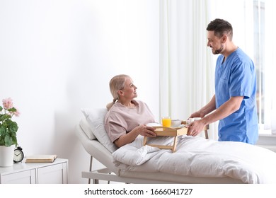 Male Nurse Bringing Food And Medicine For Patient In Hospital Ward. Doctor's Prescription