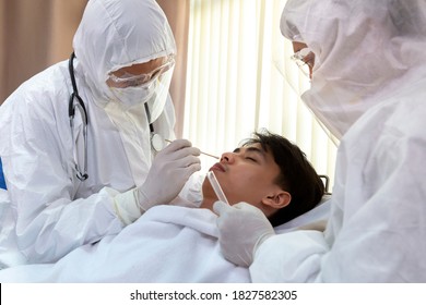 Male Nurse And Doctor Wearing Ppe Suit And Facemask Perform Coronavirus COVID-19 PCR Test. Patient Nasal NP And Oral OP Swab Sample Specimen Collection Process, Viral Rt-PCR DNA Diagnostic Procedure.