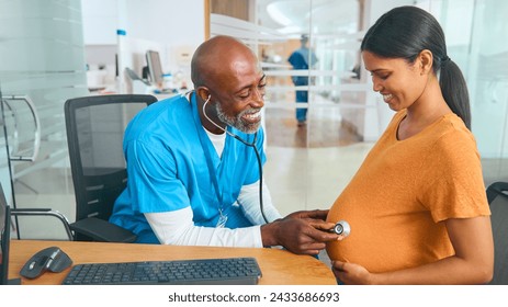 Male Nurse Or Doctor Wearing Scrubs Examining Pregnant Woman In Hospital Obstetrics Clinic - Powered by Shutterstock