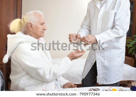 Similar – Female doctor giving medication to elderly patient