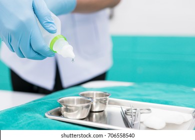 Male nurse is preparing to wound care patient. By pouring normal saline into the set dressing for cleaning patient's wound. Closed-up. Soft focus.