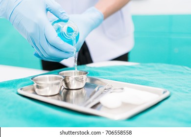 Male Nurse Is Preparing To Wound Care Patient. By Pouring Alcohol 70% Into The Set Dressing For Cleaning Patient's Wound. Closed-up. Soft Focus.