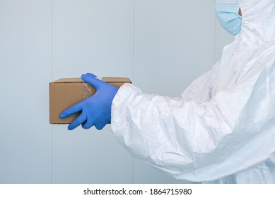 A Male Nurse In A Protective Suit PPE Shows A Box In The Hospital. Coronavirus. The Healthcare Worker Receives Medical Supplies To Care For Patients With Coronavirus Or Covid 19. Doctor Wearing A PPE.