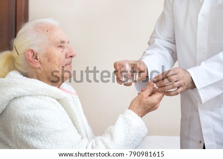 Similar – Female doctor giving medication to elderly patient