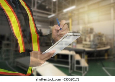 Male Occupational Health And Safety Officer Inside Factory Doing Inspection With Light Effect