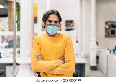 Male Office Worker With Face Mask Crossing His Arms And Looking At Camera. Co-working Concept.