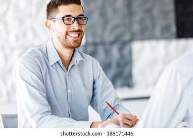 Male office worker sitting at desk - Shutterstock ID 386171446