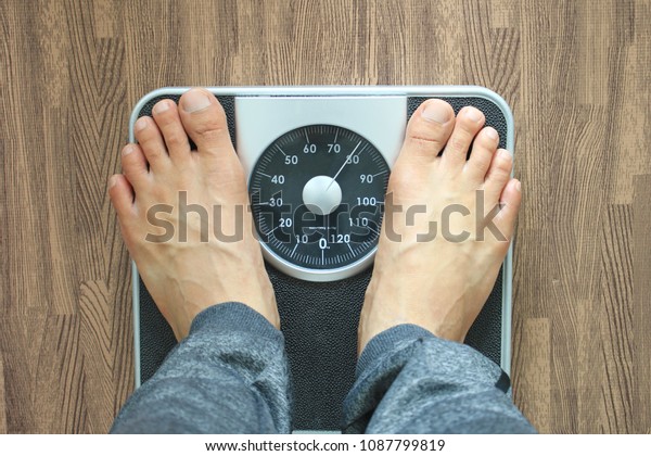 Male\
on the weight scale for check weight, Diet\
concept
