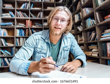 Male Online Tutor English Teacher Job Applicant Looking At Camera Teaching Student Web Class Online Lesson Training Do Videocall Make Note Communicate At Distant Job Interview In Library, Webcam View.