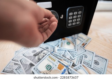 Male open with keys lock safe door against dollar money. - Shutterstock ID 2281873637