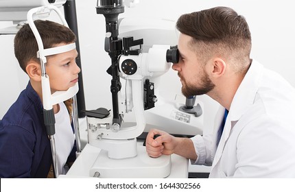 Male Ophthalmologist Checks The Eyesight Of A Teenage Boy With Special Ophthalmic Equipment. Boy Has Very Good Eyesight