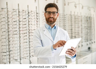 Male optician with digital tablet on background of shop windows with different models of glasses - Powered by Shutterstock