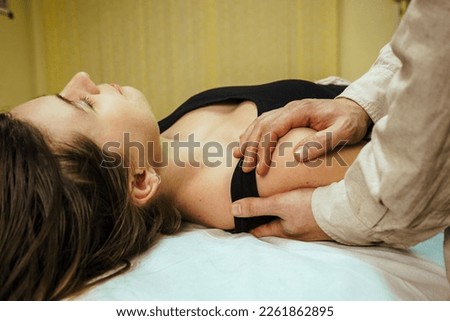 male osteopath conducts a CST treatment session for a woman, Osteopathic Manipulation and CranioSacral Therapy. 
Non-traditional medicine. Health care and head massage