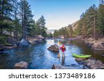 male paddler with an inflatable whitewater kayak - Poudre River below Mishiwaka, Colorado in early spring