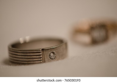 Male Palladium Engagement Ring With Diamond In Focus And Female Ring Blurred Out