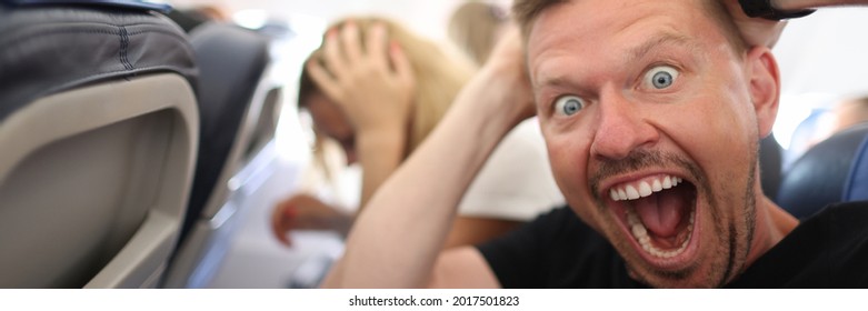 Male Passenger Holding His Head And Shouting On Plane