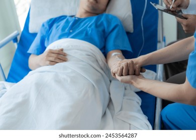 Male patient of Asian descent in bed receives good news from doctor about his recovery in hospital, health, medical and insurance concept. - Powered by Shutterstock