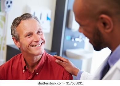 Male Patient Being Reassured By Doctor In Hospital Room