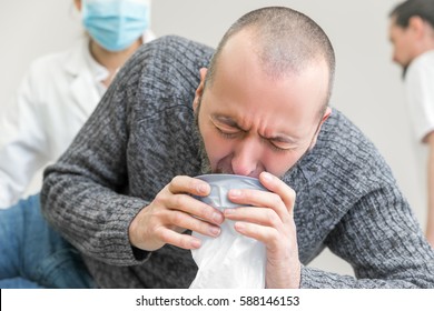 Male Patient In Clinic Is Vomiting In A Plastic Bag