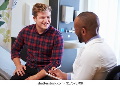 Male Patient And Doctor Have Consultation In Hospital Room