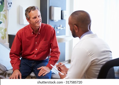 Male Patient And Doctor Have Consultation In Hospital Room