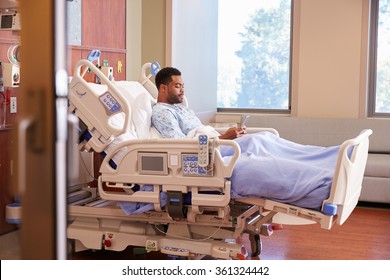 Male Patient In Hospital Bed Using Cellphone