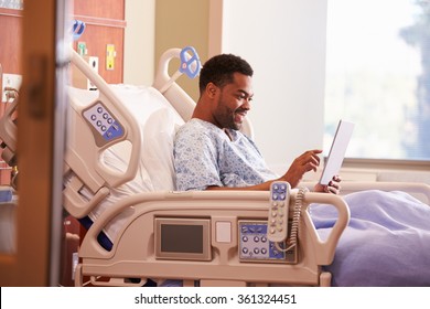 Male Patient In Hospital Bed Using Digital Tablet