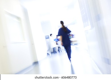 Male Patient In Hospital Wheelchair In Corridor Specialist Care Unit With Multi Ethnic Medical Staff Motion Blur