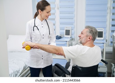 Male Patient Lifting Hand Weight Assisted By Friendly Physiologist