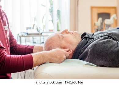 Male patient receiving cranial sacral therapy, lying on the massage table in CST ostheopathic treatment office, osteopathy and manual therapy