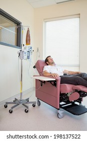 Male Patient Relaxing On Chair During Chemotherapy In Hospital Room