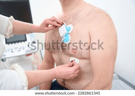 Male patient with sensors on his body to monitor arrhythmia