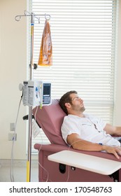 Male Patient Sleeping While Receiving Chemotherapy In Hospital Room