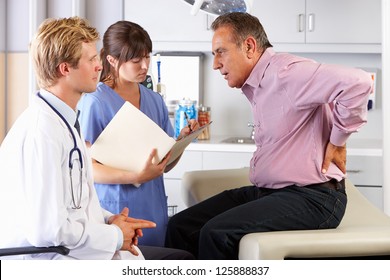 Male Patient Visiting Doctor's Office With Back Ache